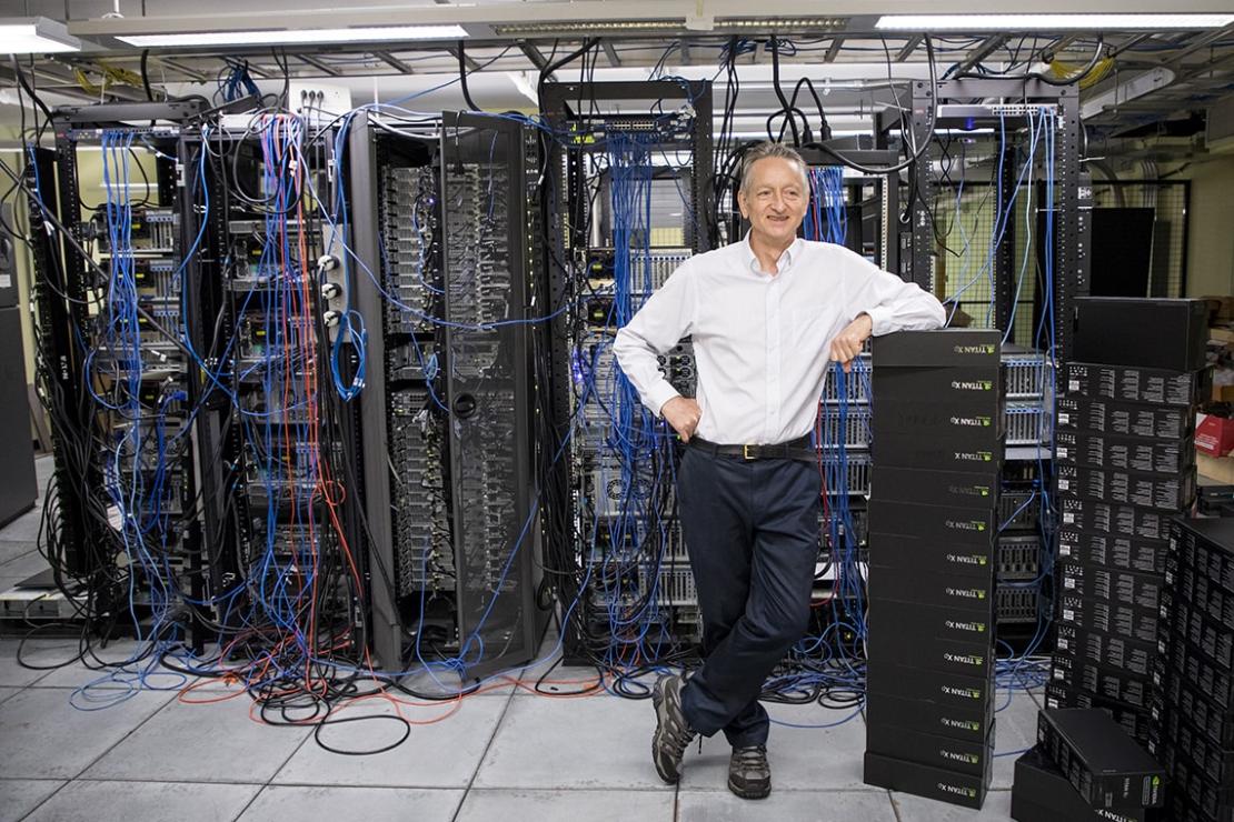 Geoffrey Hinton standing in front of AI servers