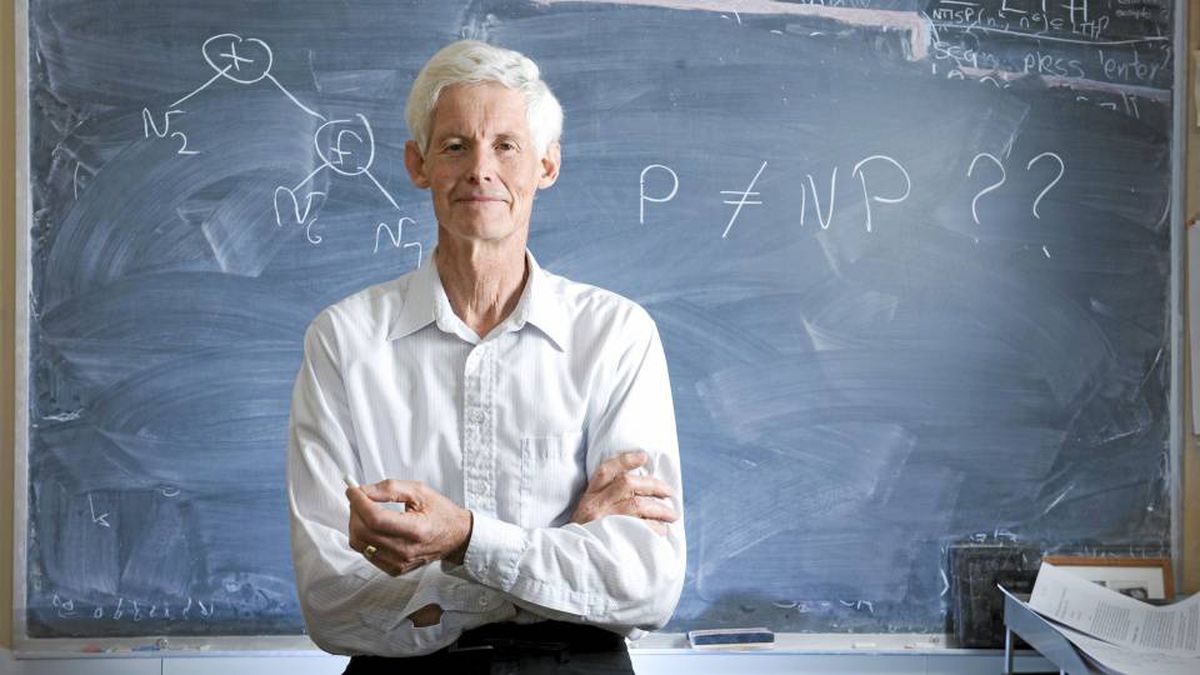 Stephen Cook in front of a blackboard with the P versus NP question